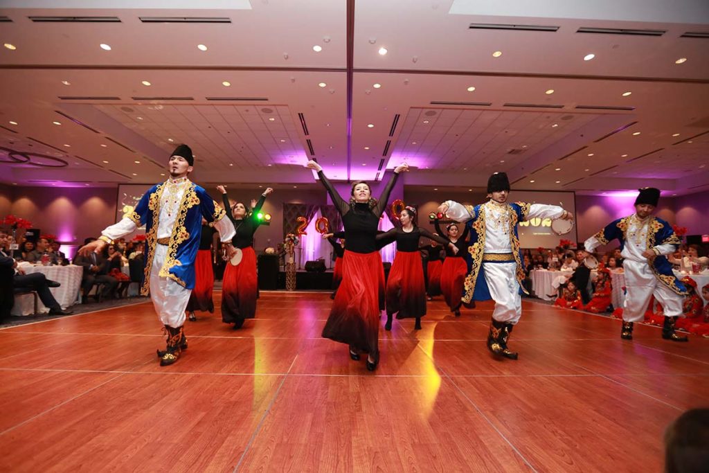 A group of Uyghurs dancing in traditional clothing.