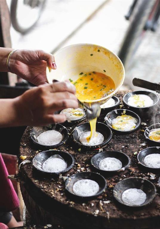 Image of a woman preparing vietnamese street food.